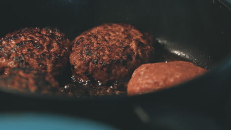 juicy burger patties are seared hot in a pan