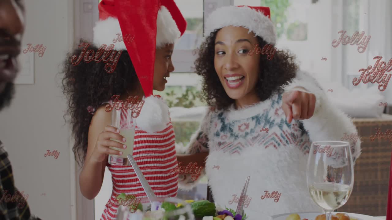 animación de saludos de navidad texto con madre y hija biracial en sombreros de santa en navidad.