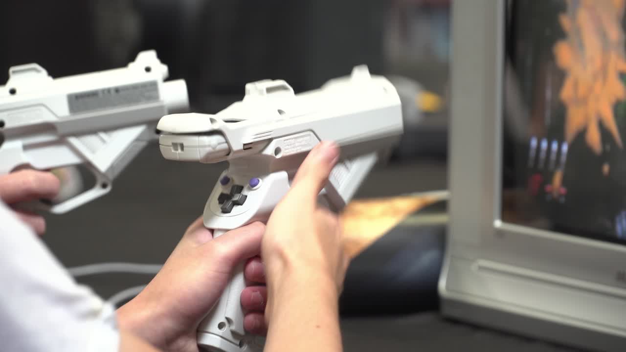 Player using light gun controller for split screen arcade style video game on CRT display