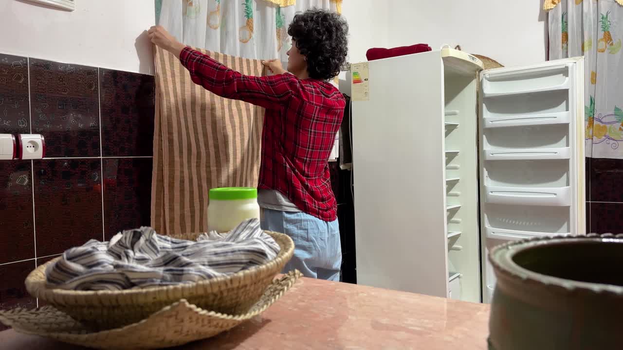 A woman measure the high height of a curtain on the window tall tailoring curtain cloth to design a house in Iran Persian culture decoration in rural village life in country side in Gilan middle east
