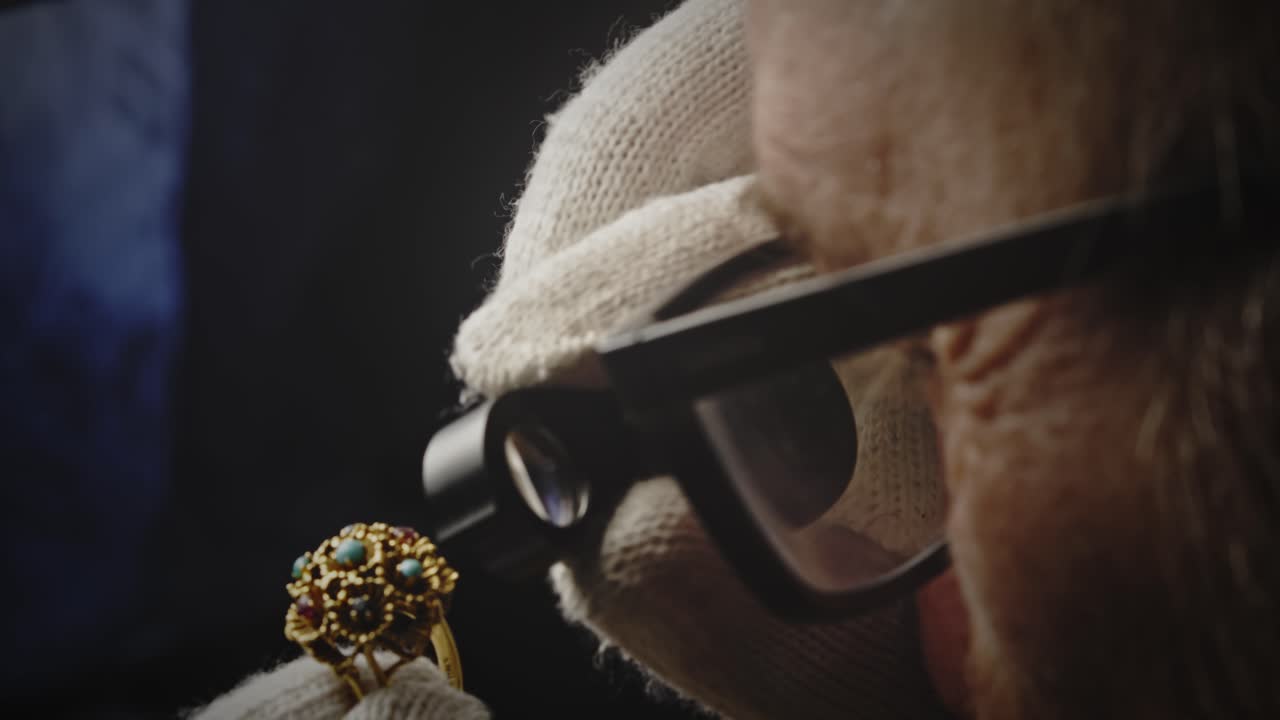 Jeweller inspects valuable gemstone ring with magnifying loupe CLOSE-UP