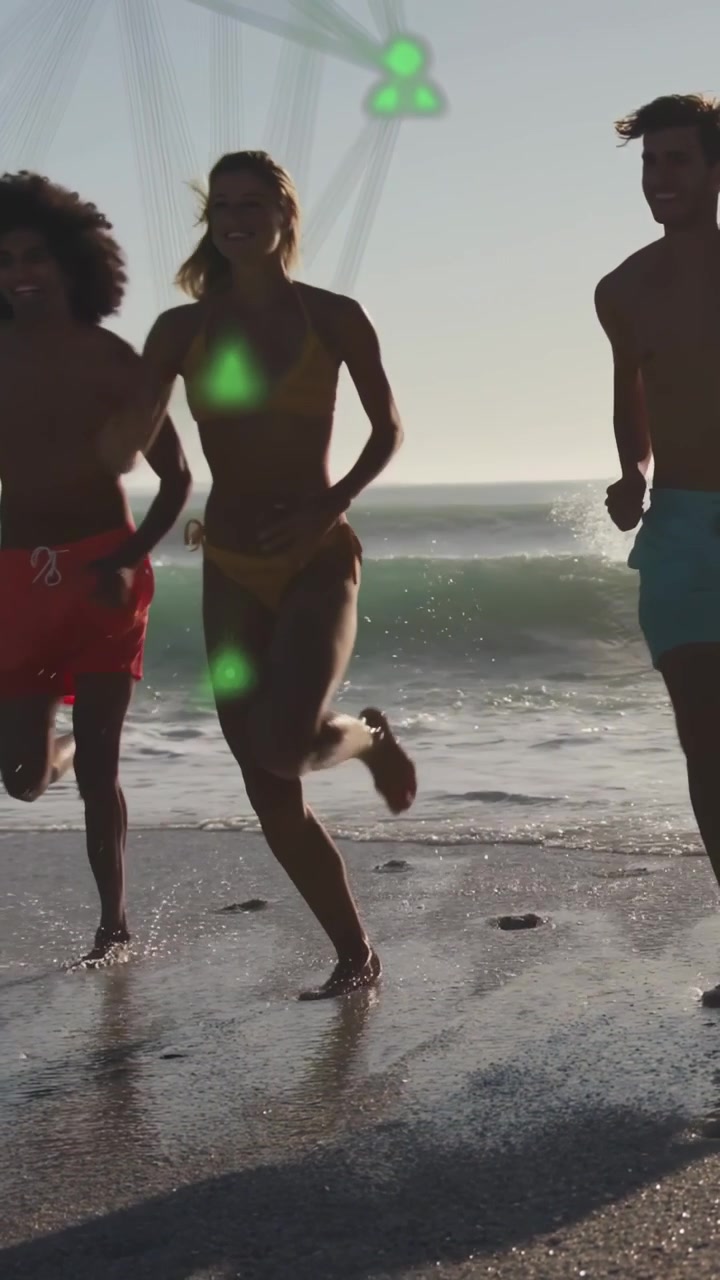 Video verticale: Amici che emergono dal surf, correndo sulla sabbia per divertimento, con nodi tecnologici che tracciano il movimento.