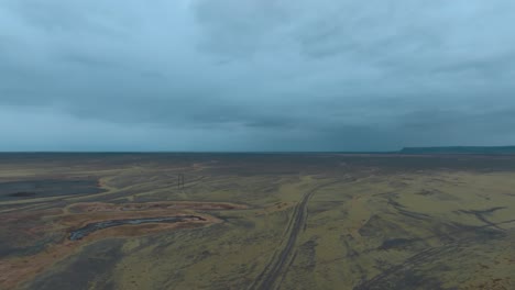 a large field of flat basalt lava from an ancient eruption in iceland covered in moss and lichen - high altitude pullback reveal