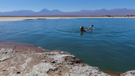 male tourist floats in extra buoyant salt lagoon in the chile desert