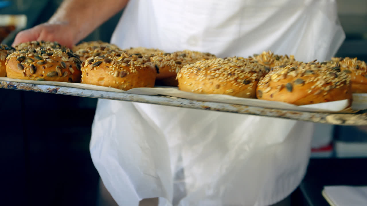 chef sosteniendo bandeja de panes horneados 4k