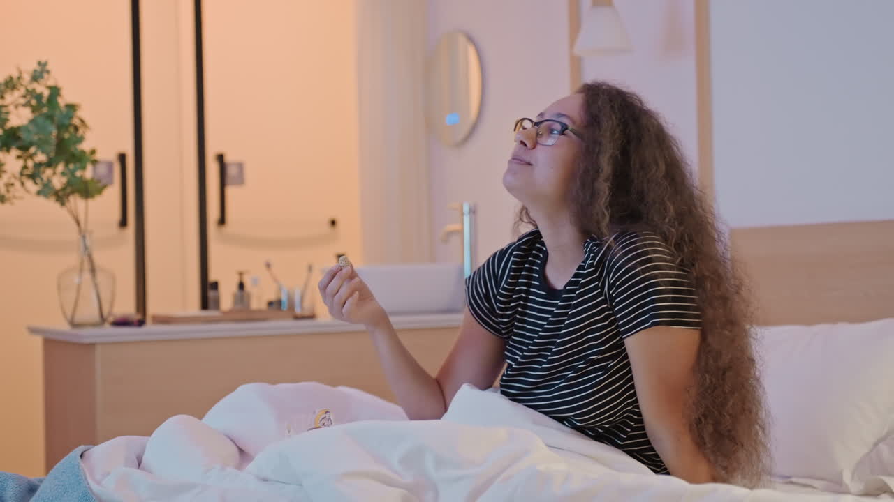 Momento di cura personale in una camera d'albergo. Donna che si dedica alla cura della pelle in un accogliente ambiente di camera d'albergo. Scena serena di una donna che si prende cura della pelle accanto allo specchio nella camera d'albergo durante un viaggio.