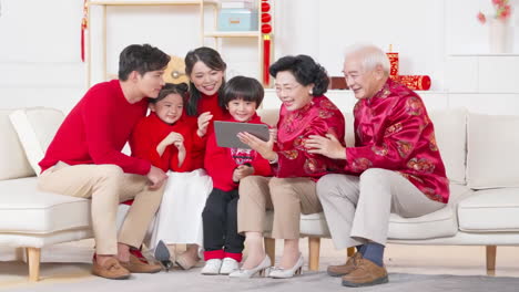 group of asia people social gathering for congratulates the new year together dinner - multi generational family sitting on the sofa chatting happily, celebrating christmas holidays