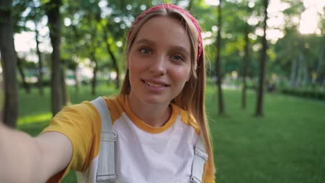 pretty girl having a video call, waving hand at camera smiling