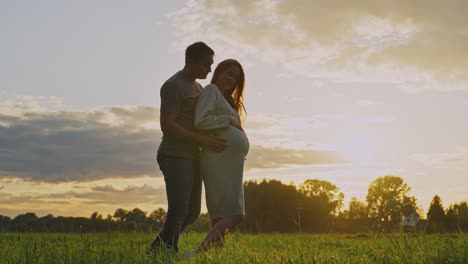 pregnant couple at sunset