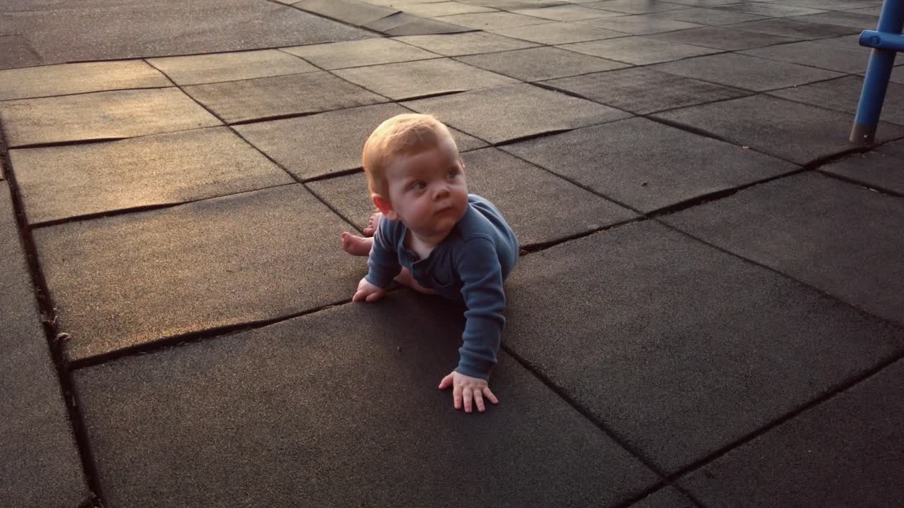un niño pequeño feliz se acuesta en una alfombra de goma mientras se pone el sol en una cálida tarde de verano