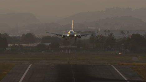 jet airplane sunset landing with smoke in slow motion