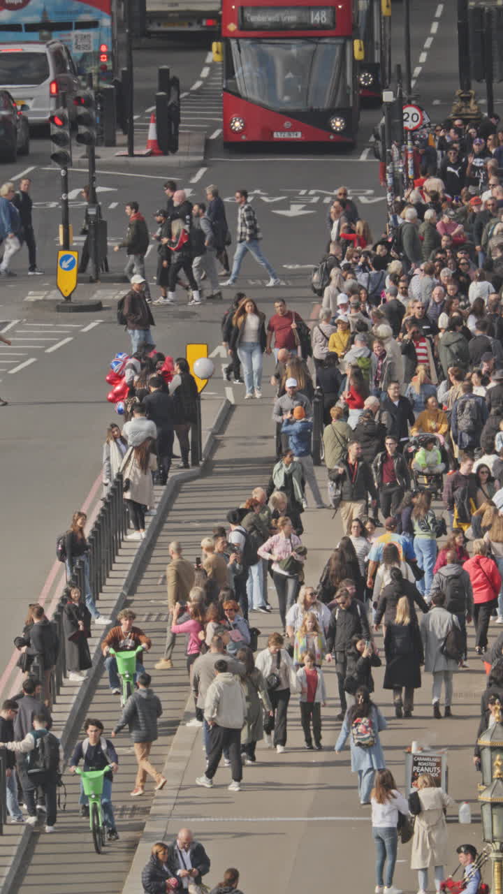 el tráfico y la gente que cruza el puente de westminster al lado de las casas del parlamento, londres, reino unido en vertical