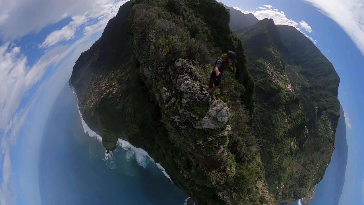 imágenes amplias de 360 puntos de vista de un hombre escalando al borde de un acantilado empinado en la cima de una montaña en madeira