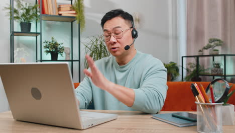 Asian-man-freelance-worker-call-center-or-support-service-operator-helpline-having-talk-with-client