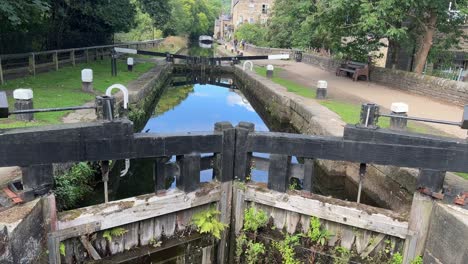 英國西約克郡 (west yorkshire) 的英國運河上的舊運河<unk>門,人們沿著拖路,步道行走