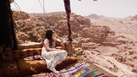 Woman-Sitting-In-A-Viewpoint-In-Petra-Ancient-City-In-Jordan---drone-shot