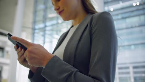 Mujer-De-Negocios-Usando-Teléfono-Móvil-En-El-Vestíbulo-De-La-Oficina-4k