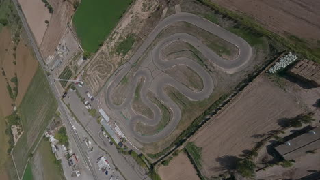épica vista de pájaro fpv aérea de pit bike track, orbitando en el circuito de deportes de motor