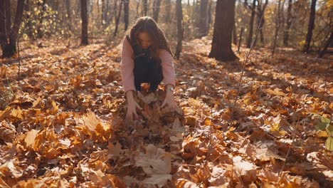 woman enjoying autumn leaves in a forest