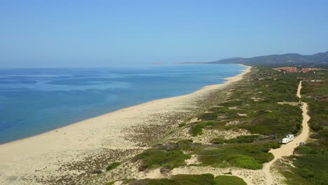 Impresionante-Vista-De-La-Playa-De-Arena-Con-Vegetación-Verde-Cerca-Del-Mar-Azul