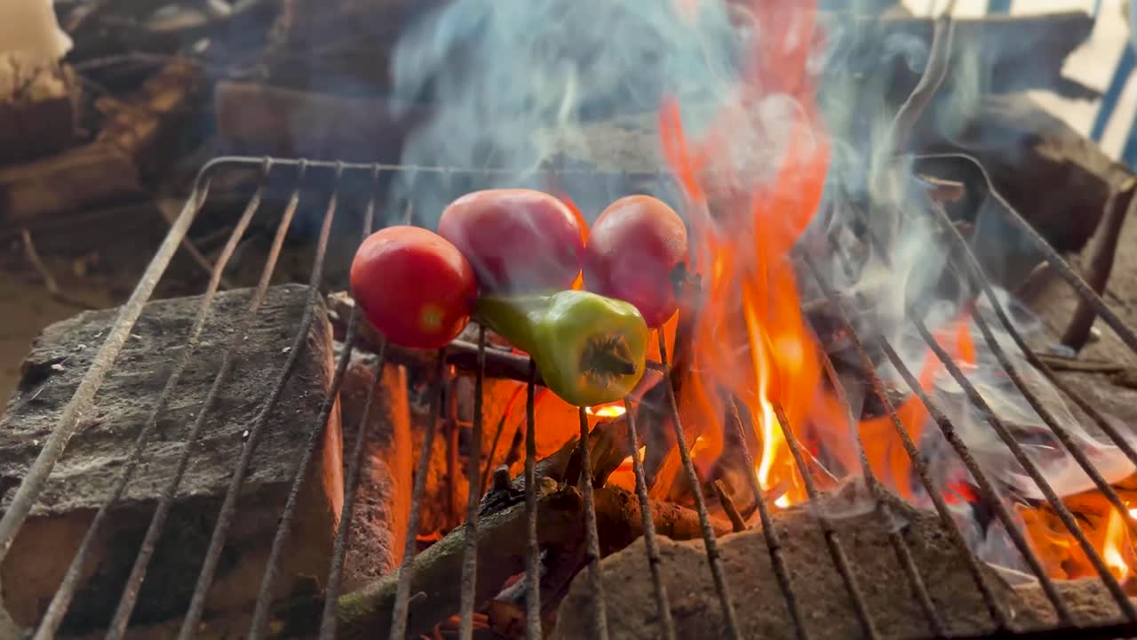Delizie affumicate: Pomodori e peperoncini su una griglia a legna.