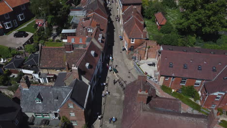 Shot-of-Steep-Hill-in-Lincoln-Old-Street-with-People-Walking-Up-and-Down-and-Roman-and-Victorian-Architecture-on-Sunny-Day-UK