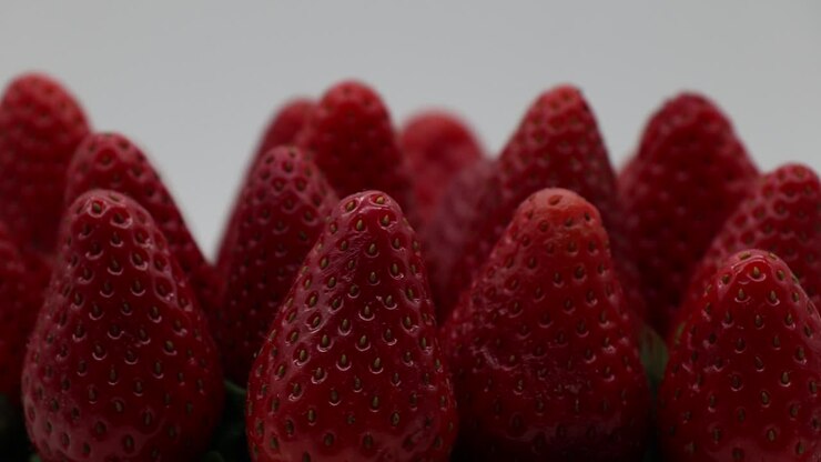 Fresh ripe strawberries on white display rotating