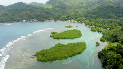 coastal panama island turquoise bay tilt up aerial view to tropical jungle mountains