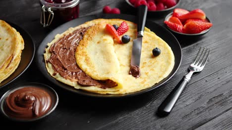 delicious chocolate homemade pancakes on black ceramic plate