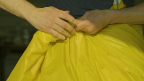 Caucasian-skydiver-meticulously-inspects-and-folds-parachute-before-dive