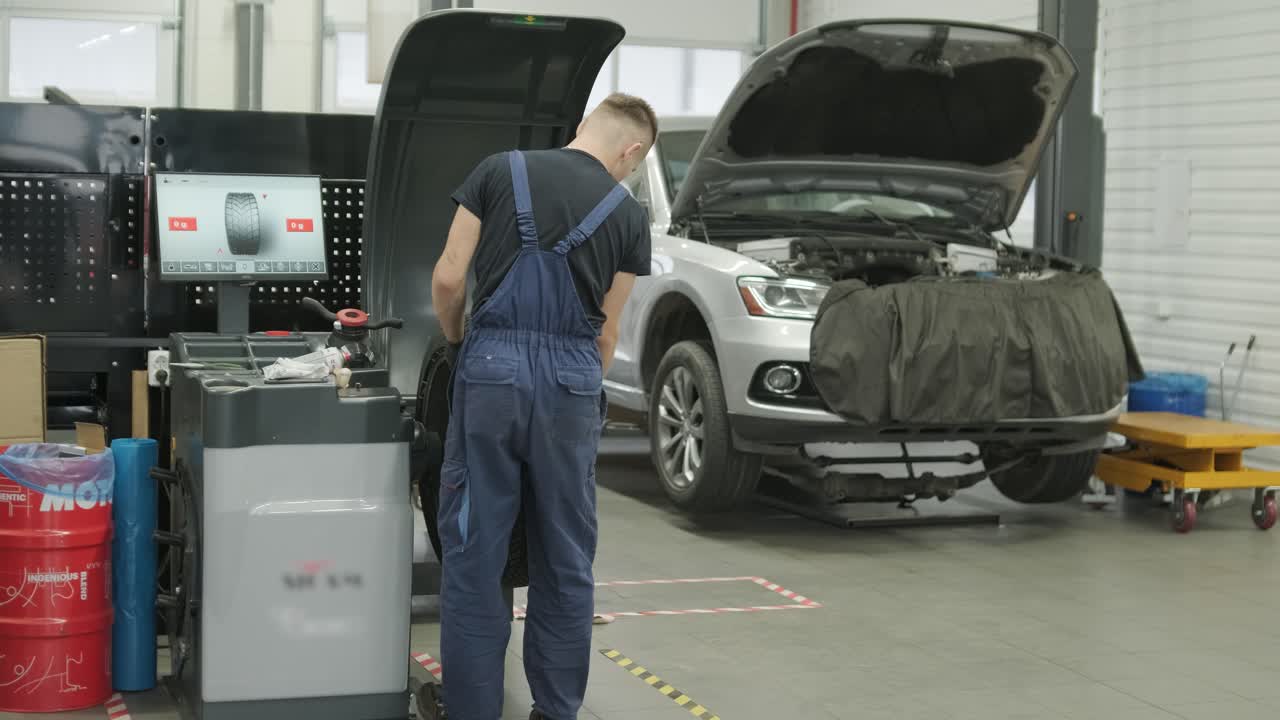 Mechanic Working on Car Tire in Auto Repair Shop