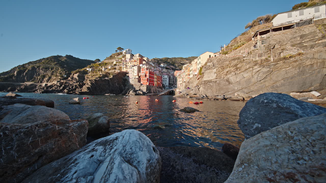A calm coastal view of Riomaggiore with colorful buildings by the sea