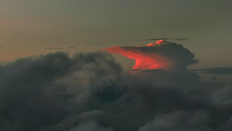 aerial flight above dark clouds illuminated by sun behind horizon