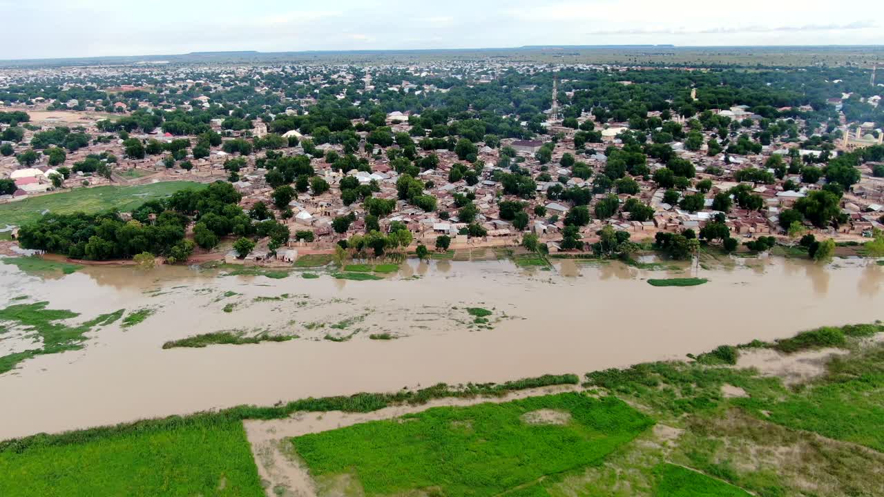 The flooded banks of the Sokoto River in Argungu Town of Nigeria in the Kebbi State - sliding aerial view