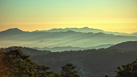 sun rays stream through cloud mist haze on green yellow mountains