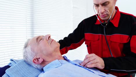 Male-paramedic-examining-a-patient