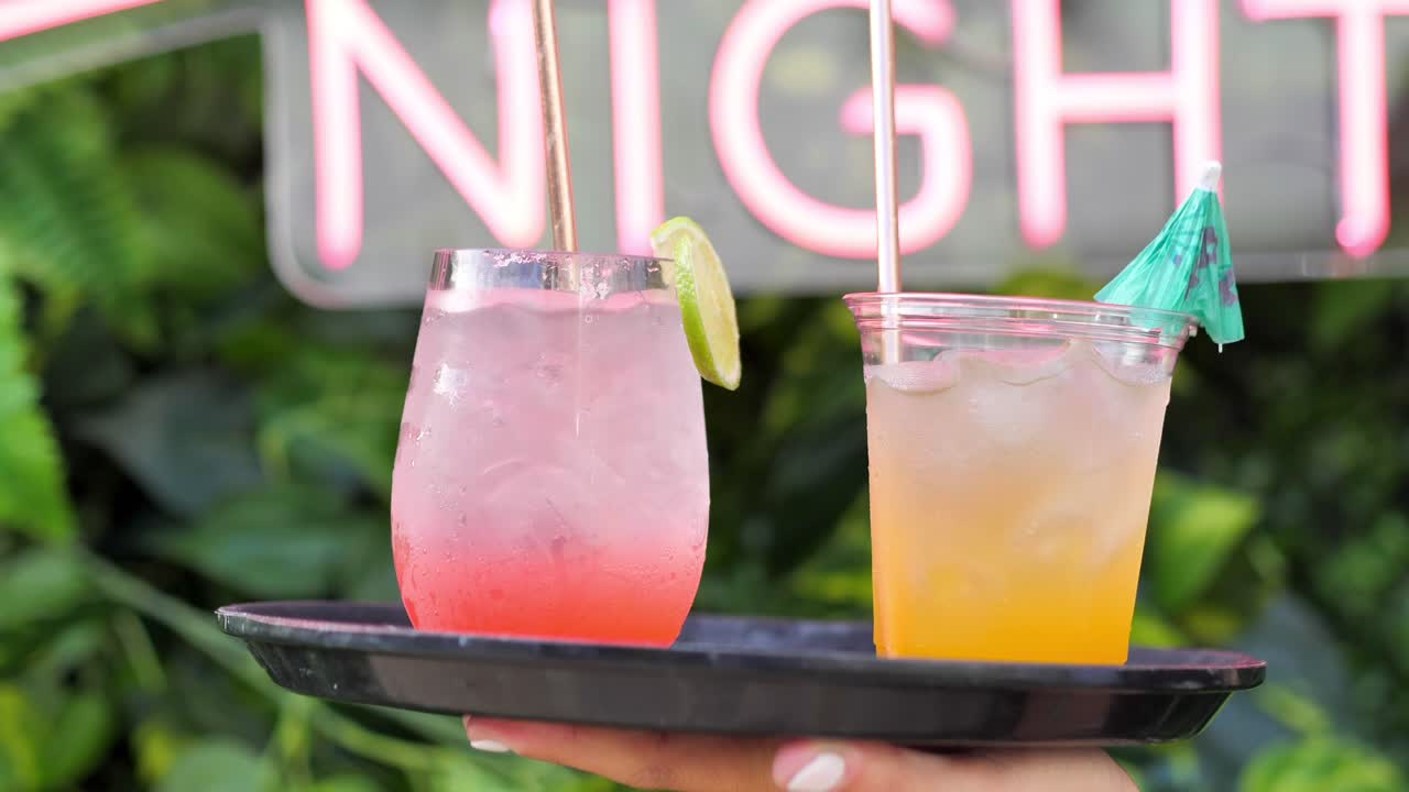 fwaiter sosteniendo una bandeja de dos copas de bebida con champán muestra a los visitantes