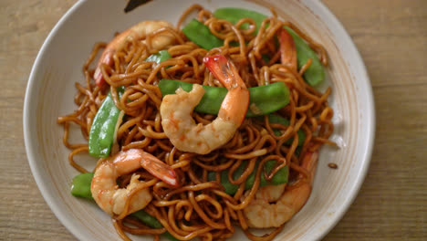 stir-fried yakisoba noodles with green peas and shrimps - asian food style