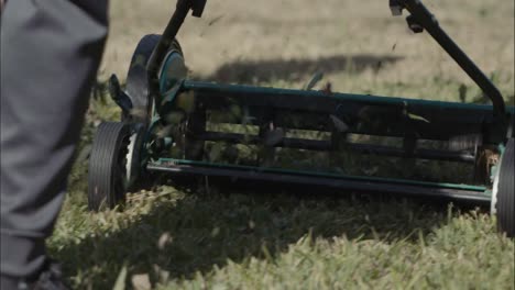 Pushing-a-manual-mower-across-rough-grass