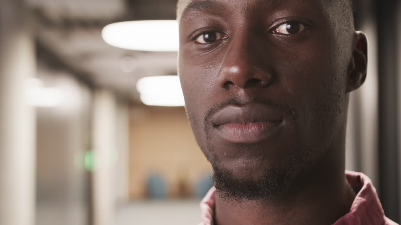 Close-up of confident businessman in office hallway, looking at camera