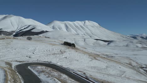 a drone footage over castelluccio - italy during winter period with snow