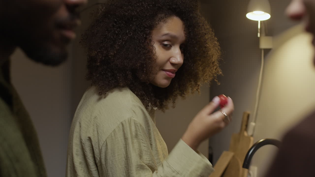 Woman eating a tomato with friends