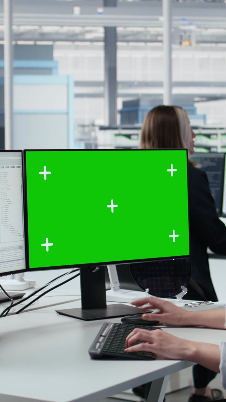 Vertical video Green screen PC used by woman coding in microchip factory office