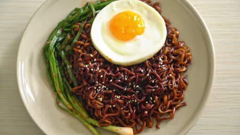 homemade dried korean spicy black sauce instant noodles with fried egg and kimchi