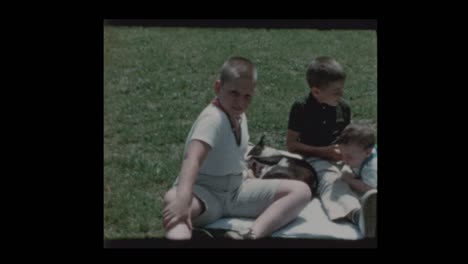 2 boys and baby play with dog