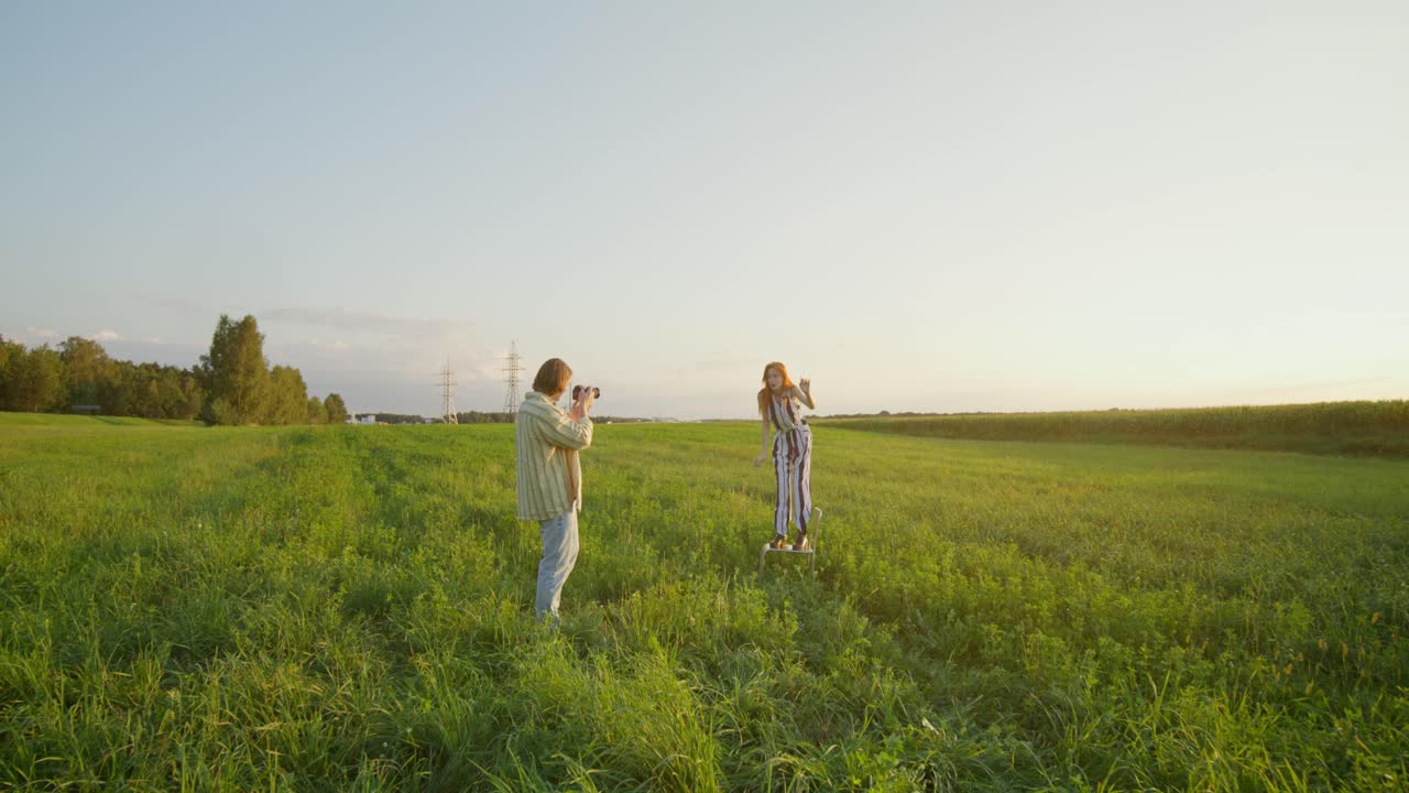 사진작가 가 해가 지는 들판 에서 스케이트보드 를 타고 있는 모델 을 포착 하고 있다