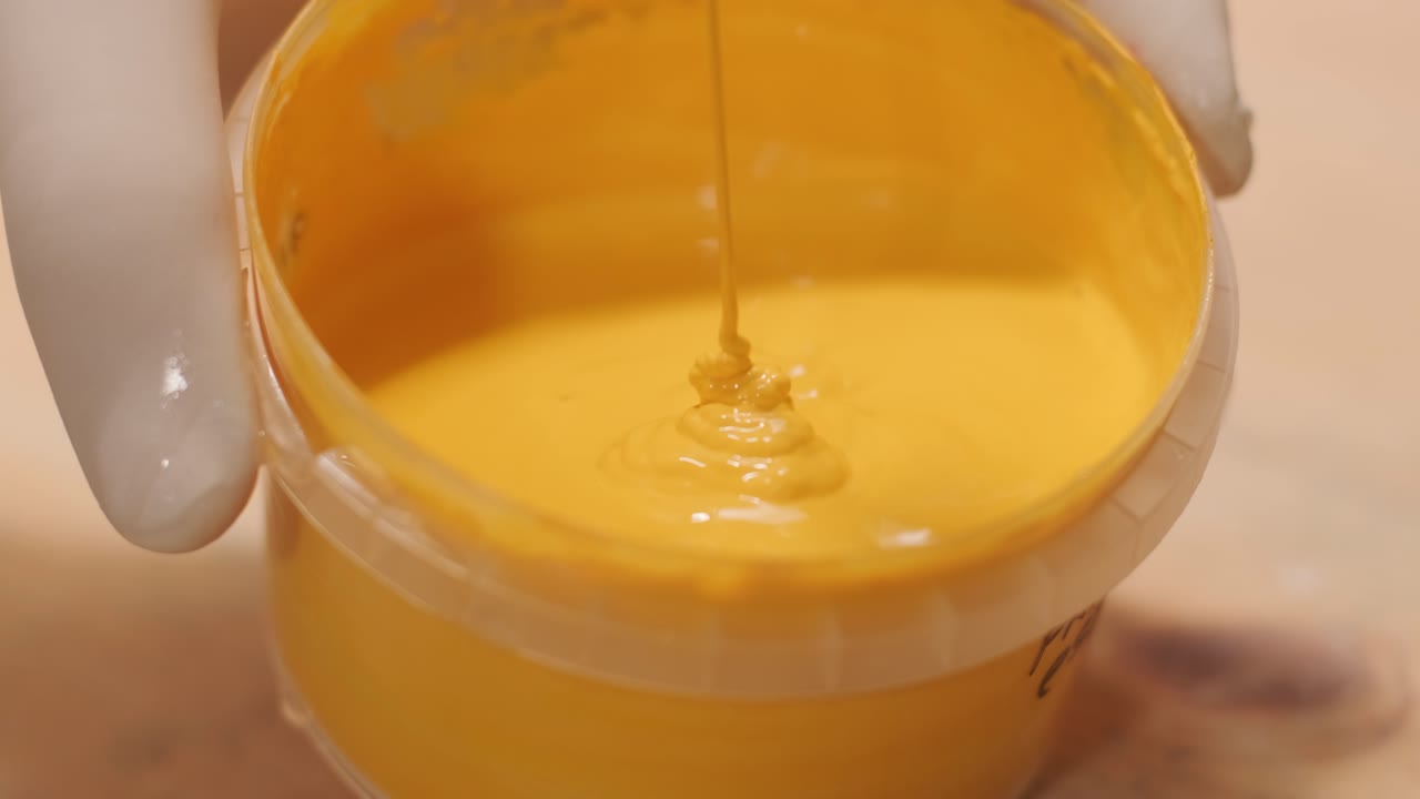 un trabajador amasa la pintura para pintar las paredes