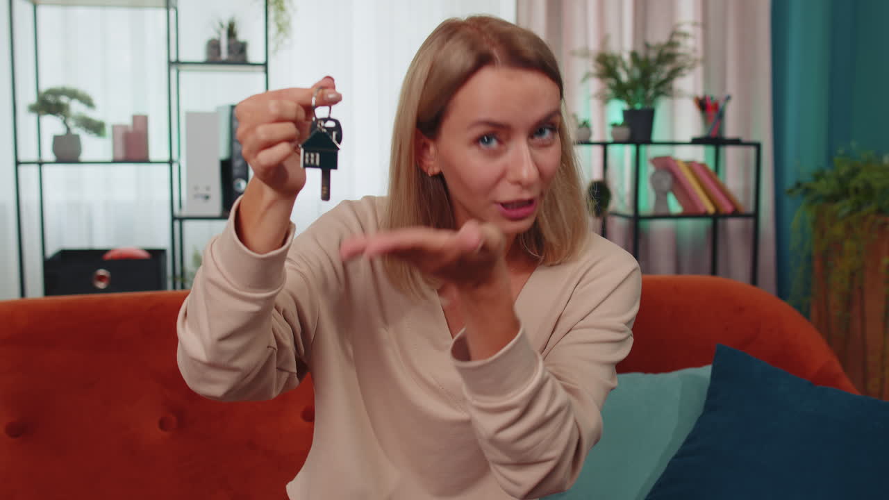 mujer agente de bienes raíces que muestra las llaves de una nueva casa, apartamento, compra o alquiler de una propiedad