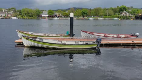 el agua del río refleja la luz del sol en el gunwale de un viejo motorboat de madera