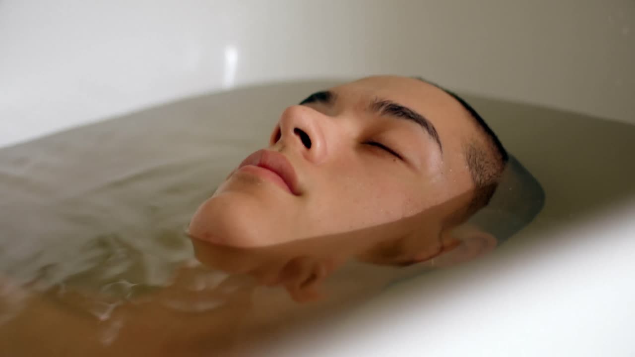 욕실 4k에서 욕조에서 목욕하는 남자